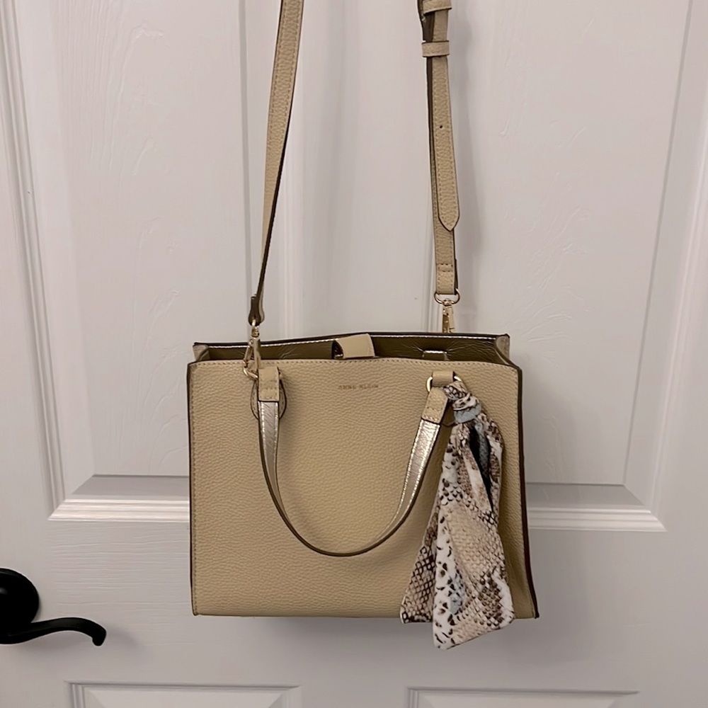 Beige Anne Klein purse with adjustable straps and storage space.